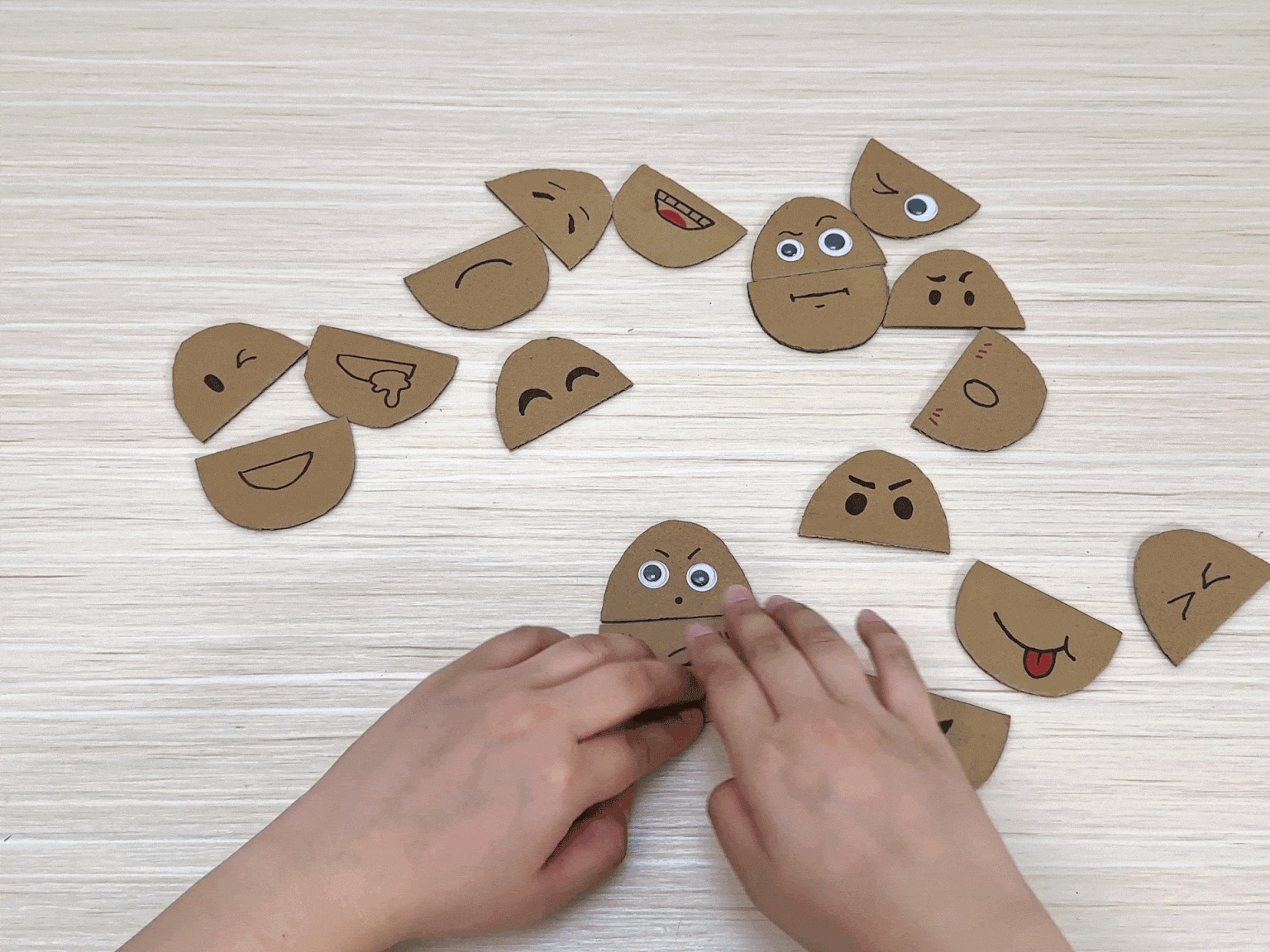 Hands demonstrate a sewing activity using a cardboard cutout of a fish. Numbered holes are punched along the fish's outline, and yarn is threaded through the holes, creating a stitching effect.