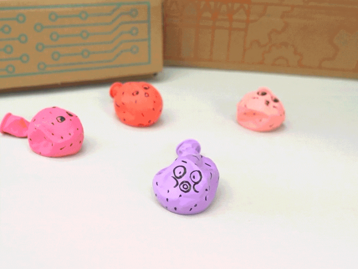 Crikey! Look at those cheeky chappies! Three little pufferfish, crafted from balloons and adorned with cute faces, sit on a light surface near a box. Ready to inflate and deflate with a bit of science magic!