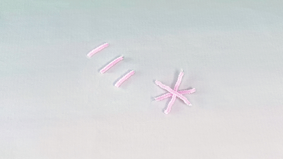 There we have it, our pipe cleaner shapes all ready to go! A snowflake and three short lengths, all in a lovely shade of pink, sit neatly on the surface, ready for their crystal coating. It's all rather delightful, innit?