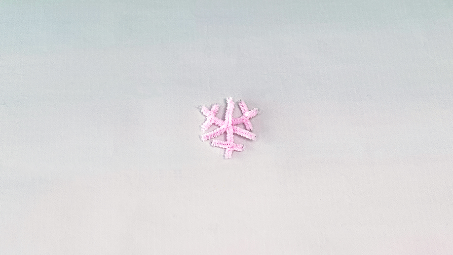 There's our snowflake, all ready for its sparkly makeover! A delicate pink design, crafted from pipe cleaners, sits patiently waiting for its crystal coating. It's looking rather lovely, innit?