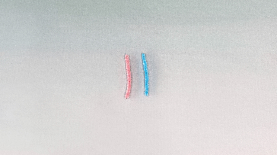 There we are, our candy cane ready for its crystal coating! A pink and blue pipe cleaner, all twisted and ready to be transformed into a sparkly festive treat. It's all rather sweet, innit?