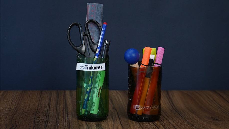 Cor blimey, look at those crafty pen pots! A couple of old bottles have been given a new lease of life, transformed into rather spiffing holders for pens, pencils, scissors, and even a ruler. They're a proper jolly pair, aren't they? What a brilliant bit of recycling!