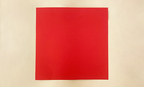 There we have it – a lovely bit of red paper, all ready for some folding fun! It's a proper vibrant colour, innit? Let's see what sort of crafty creation we can conjure up with this.
