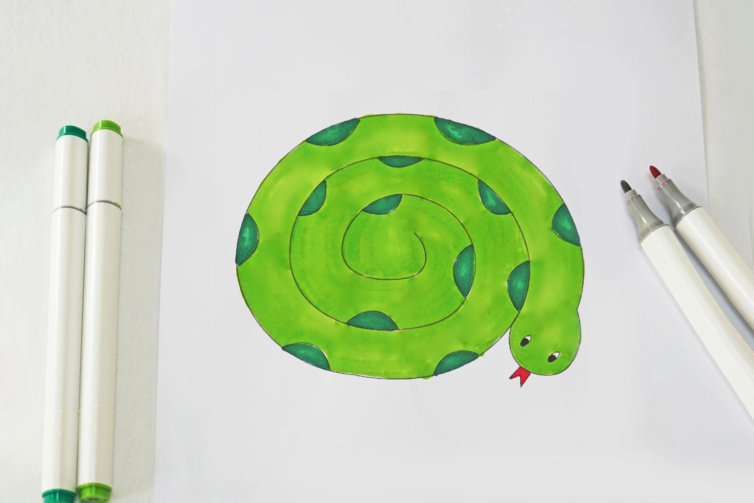 A simple line drawing of a coiled snake is being brought to life with vibrant shades of green, ready for its transformation into a spinning heat-powered marvel.