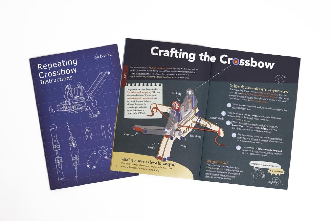 An open instruction booklet for a DIY repeating crossbow kit. The booklet features detailed illustrations and explanations of the crossbow's mechanics and how to build it. The booklet is designed to be engaging and informative, with a playful tone and fun illustrations.